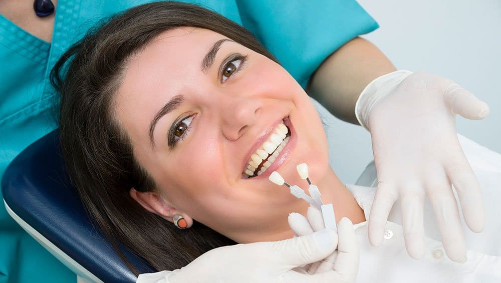 Woman with dental implant color samples