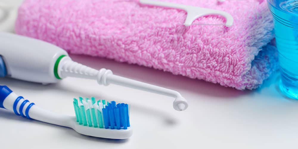 Close up of toothbrush, flosser, towel, and mouthwash